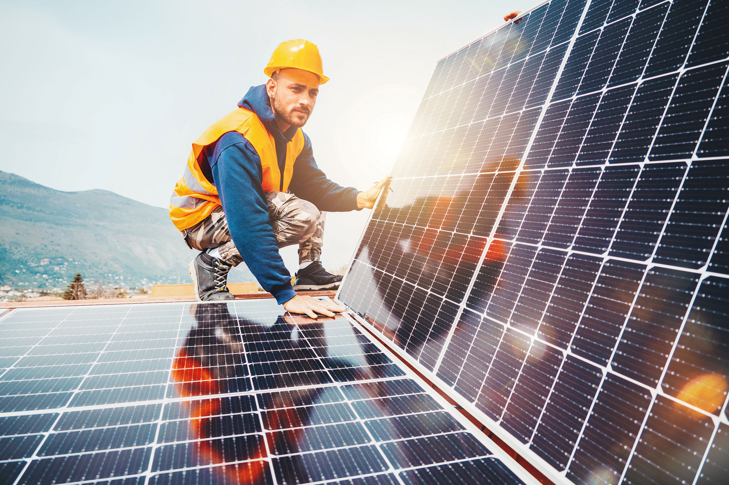 Technicien Wattéco assemble un système énergétique avec un panneau solaire pour l'électricité